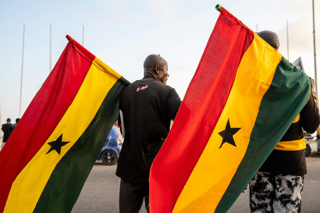 pexels photo 35039209 35039209 Two men holding Ghanaian flags during a public event in Ghana, capturing national pride.